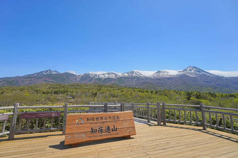 The Shiretoko mountain range behind a wooden viewing deck