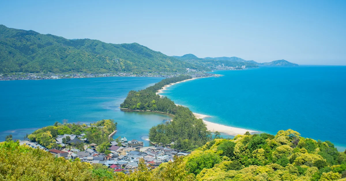 The pine-covered Amanohashidate sandbar between blue bays, seen from View Land