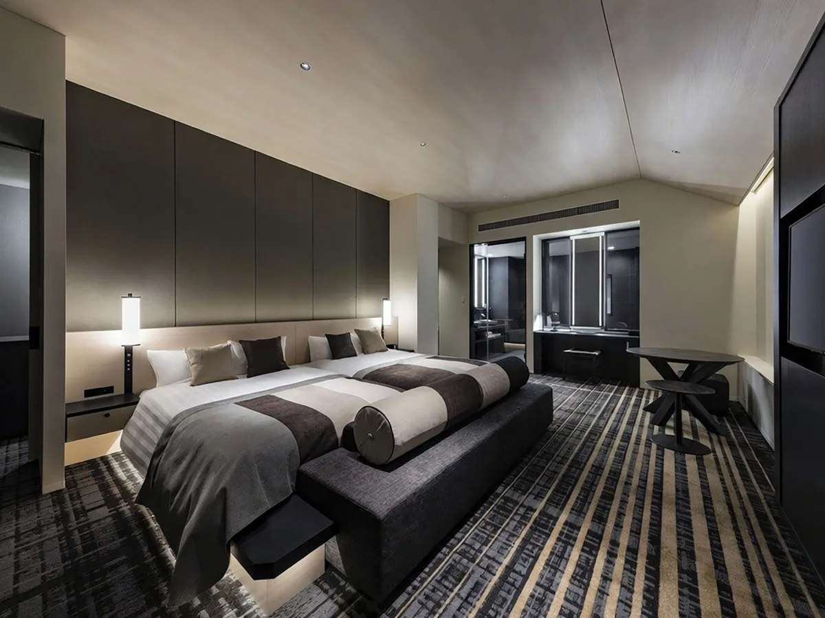 Beds and a seating area in a guest room at Hotel Hankyu RESPIRE OSAKA