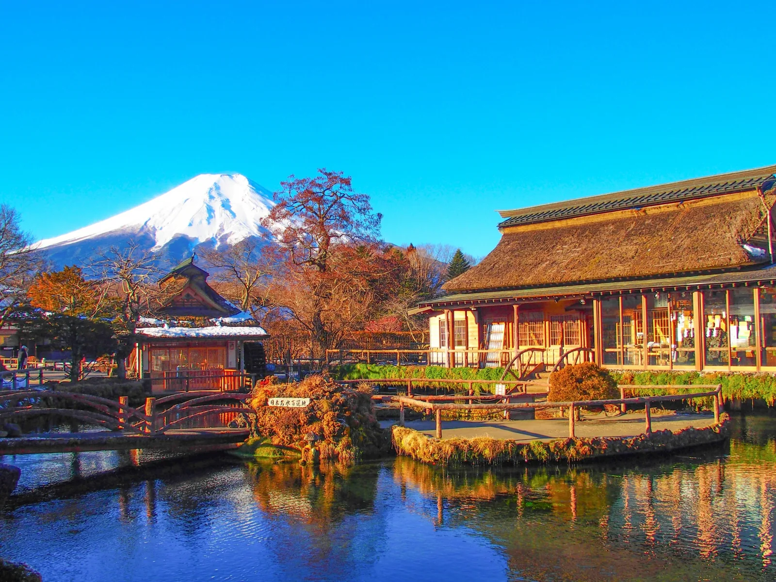Mount Fuji rising behind the ponds and traditional buildings of Oshino Hakkai