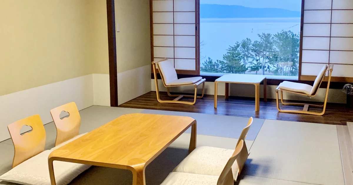 Japanese-style room with tatami flooring, low seating and a window overlooking the water