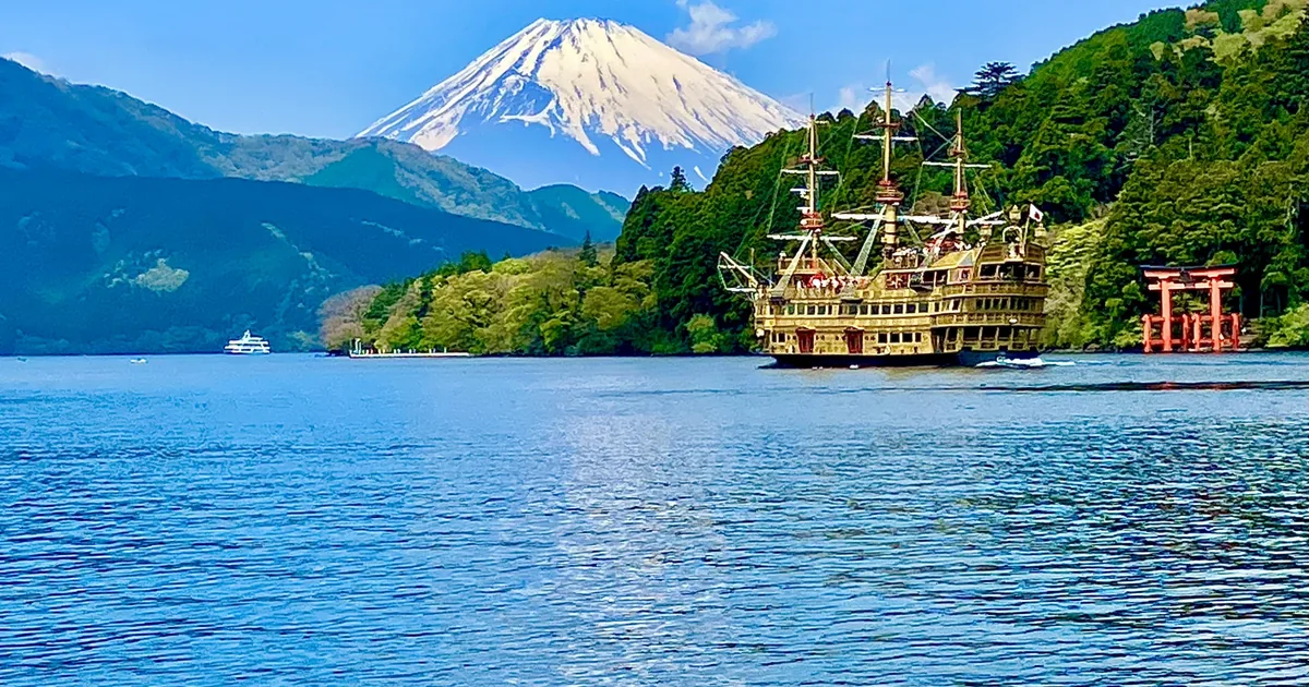 A sightseeing pirate ship on Lake Ashi, with Mount Fuji and Hakone Shrine's lakeside torii in the background