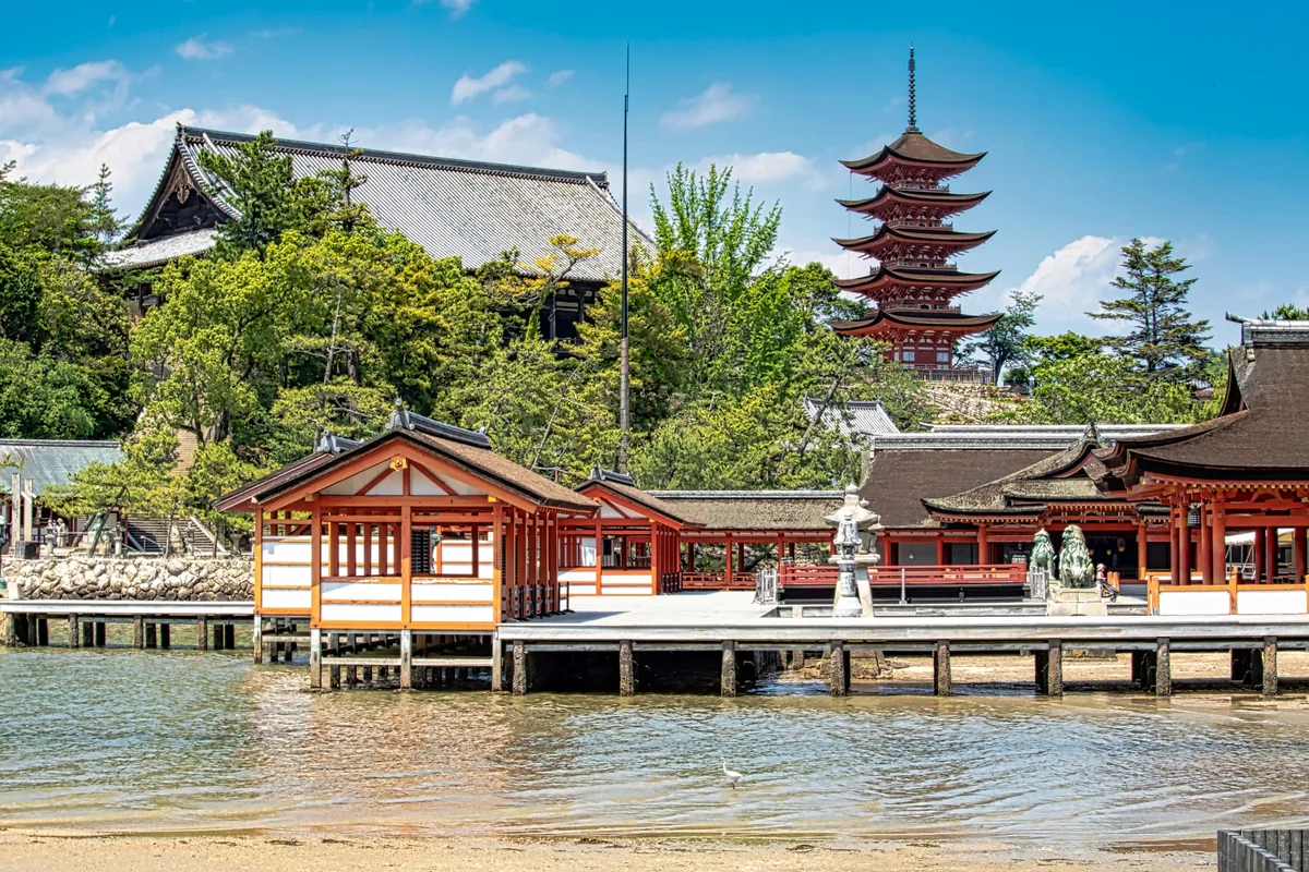 Itsukushima Shrine beside the water, with Miyajima's five-story pagoda rising behind it