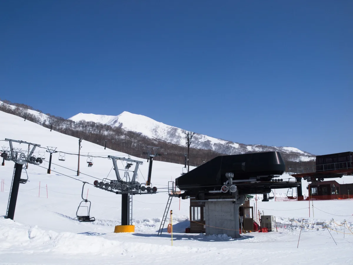 A chairlift boarding station and snow-covered slopes in Niseko