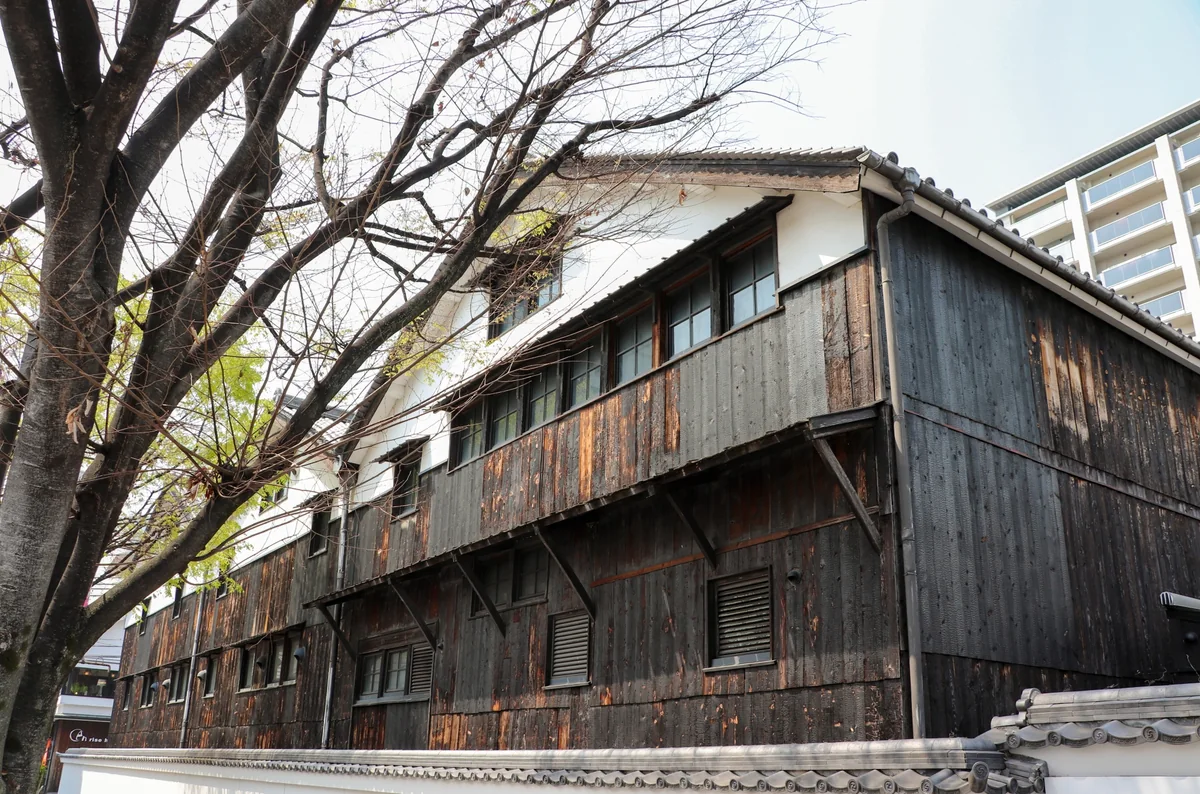 Weathered timber walls and upper windows of Chojugura in Itami
