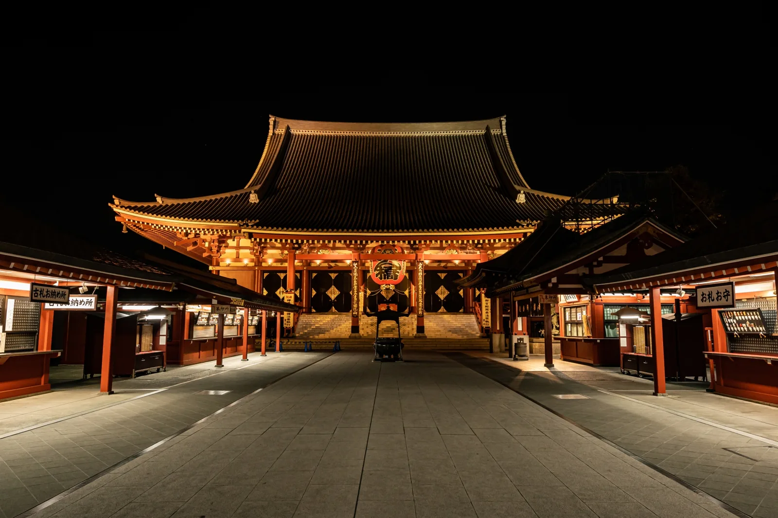 The illuminated Sensoji main hall beneath a black night sky