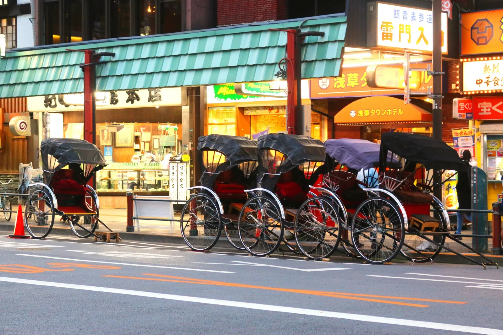 A row of traditional rickshaws waiting on an Asakusa street