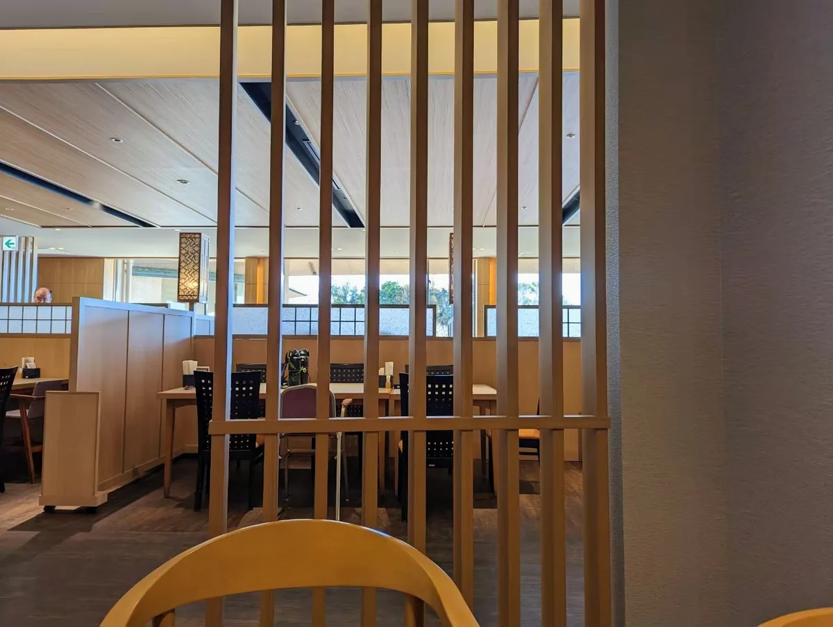 用餐空間內的桌椅,座位之間以木製屏風及直立木條區隔