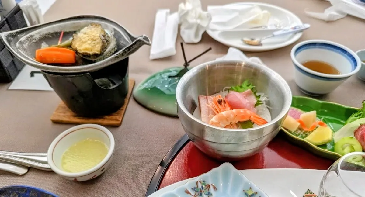 我們晚餐桌上的鮑魚陶板料理、金屬盛器中的生魚片與數道小菜