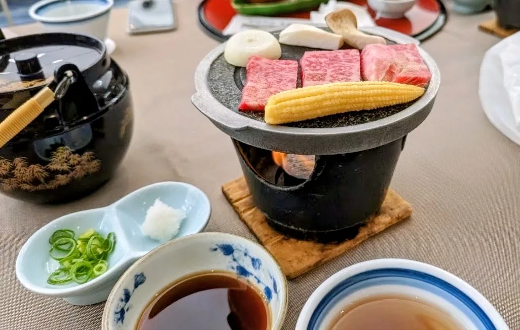 晚餐石板上的油花牛肉、玉米筍、洋蔥與菇類