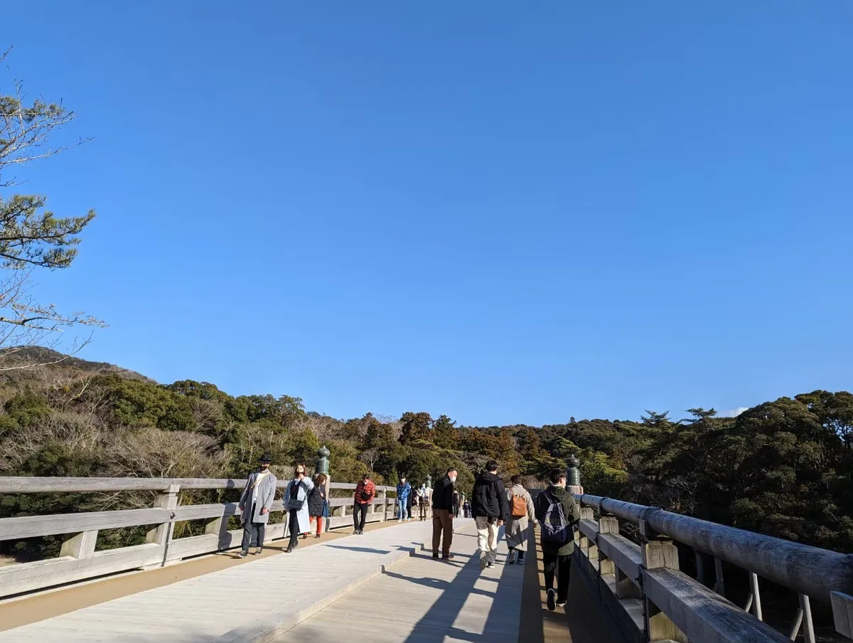 晴空下的伊勢神宮宇治橋,橋上有木製欄杆,前方可見鳥居