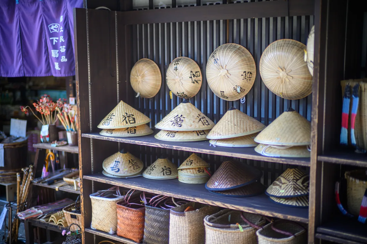 Traditional straw hats and woven goods displayed at a shop in Magome