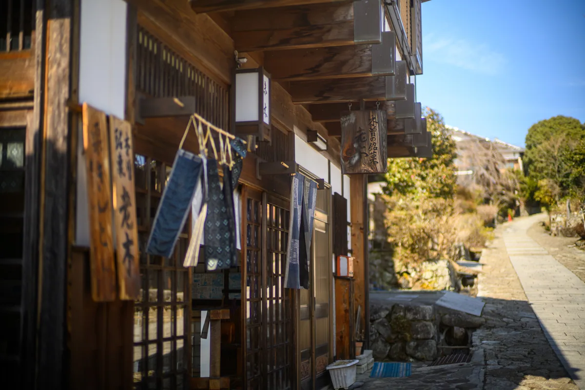 A timber shopfront beside the paved street in Magome