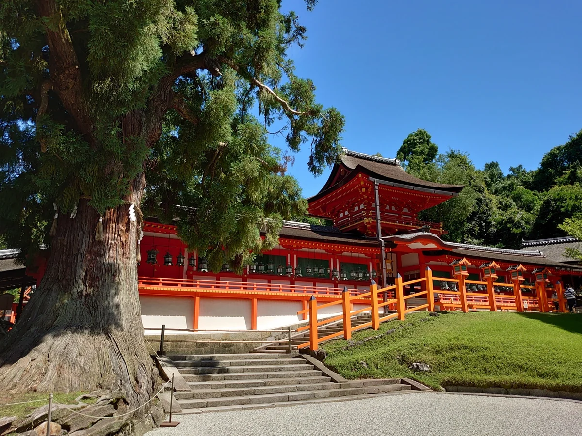 Kasuga Taisha's vermilion Chumon gate and Oro veranda behind trees and stone steps