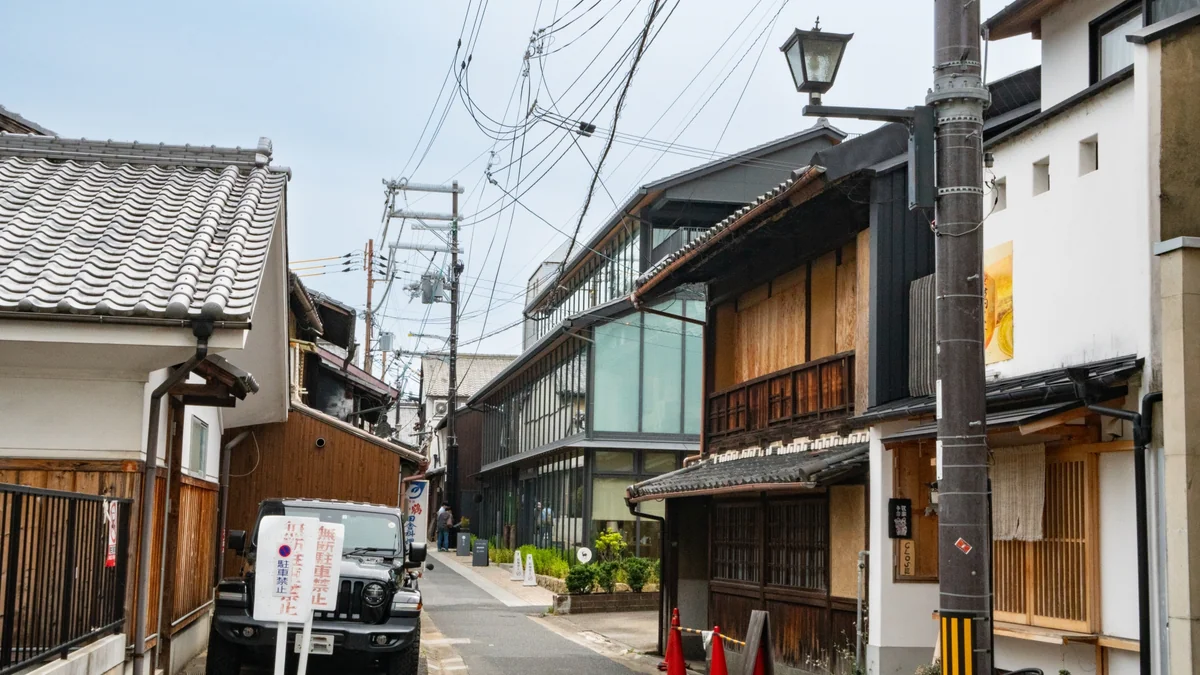 Traditional wooden facades and tiled walls along a quiet Naramachi lane