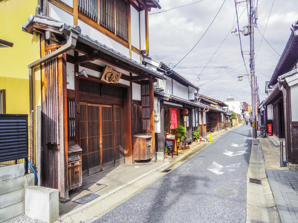 A narrow Naramachi street with wooden shopfronts and tiled roofs