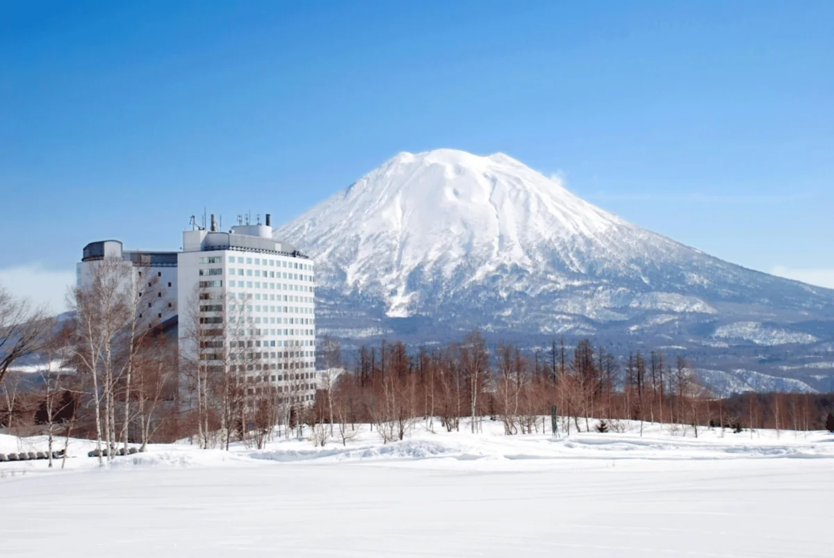 Hilton Niseko Village with snow-covered grounds and Mount Yotei behind it