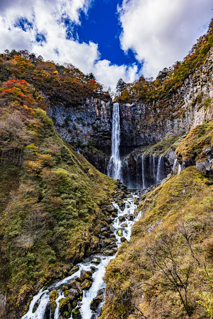 Kegon Falls drops through a rocky gorge framed by autumn woodland.