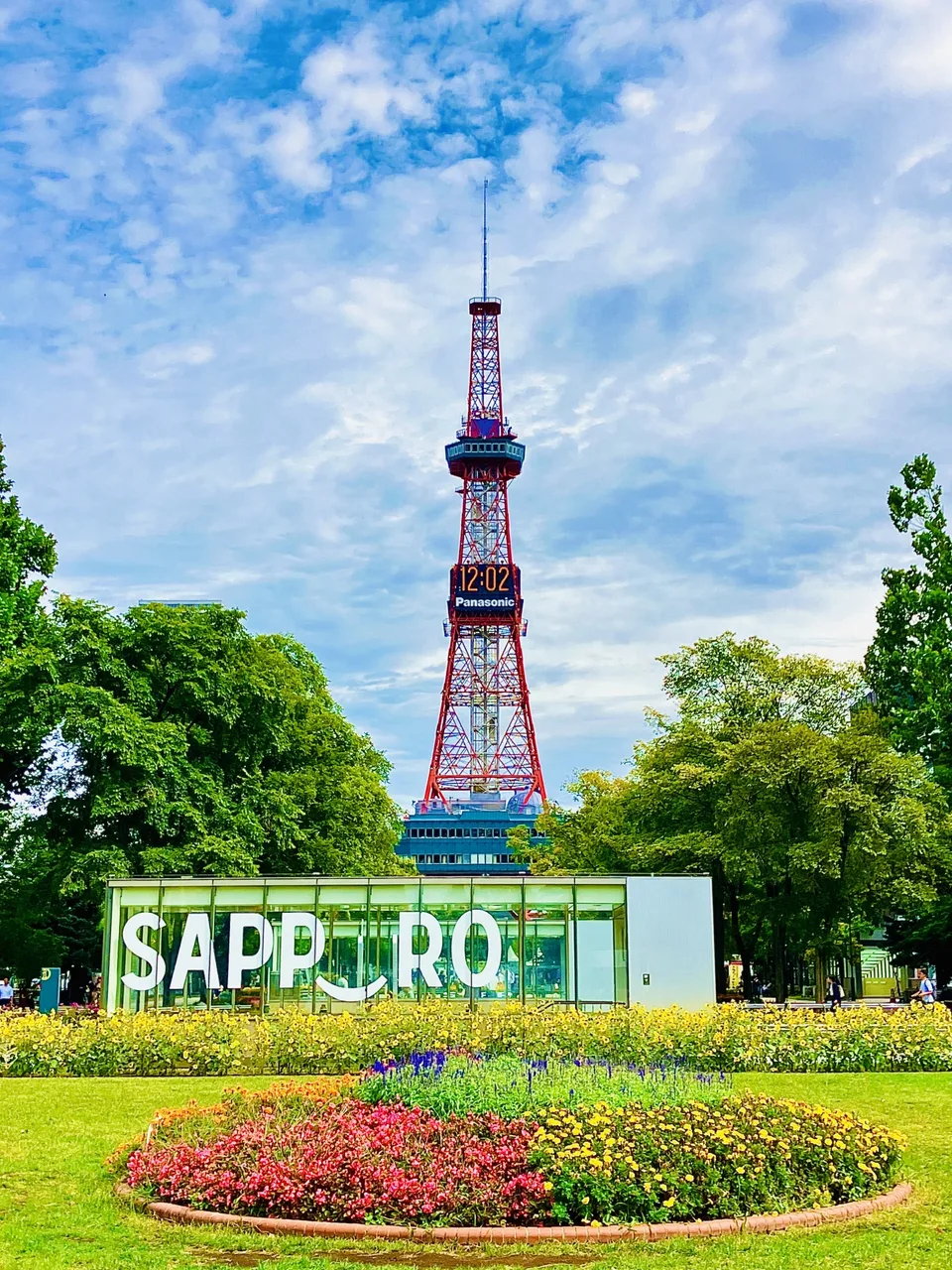 Sapporo TV Tower above summer flowers and a Sapporo sign