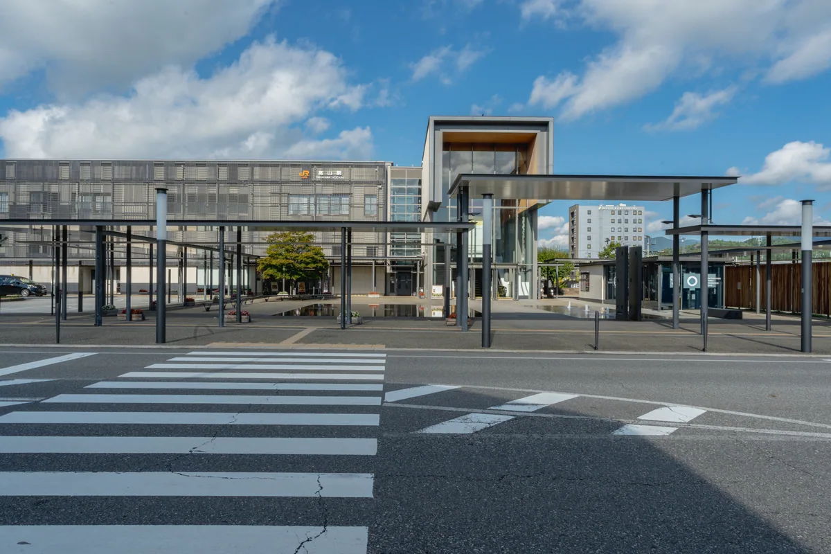 Modern Takayama Station building beyond a pedestrian crossing