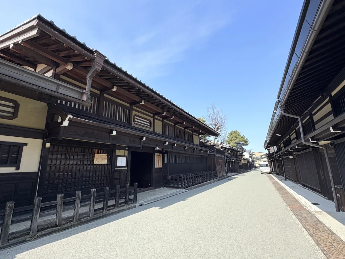 Historic dark-timber buildings lining a sunlit street in Takayama