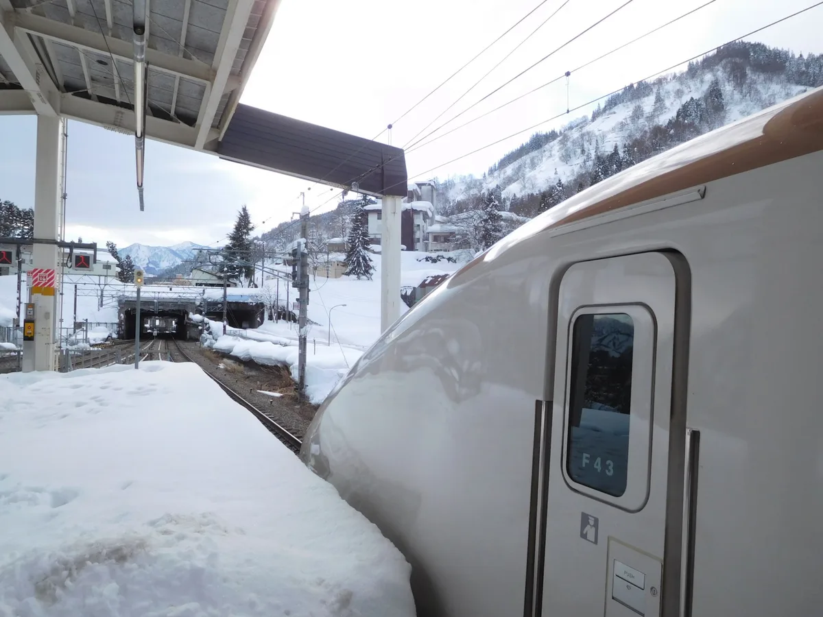 A Joetsu Shinkansen train standing beside deep snow at GALA Yuzawa Station