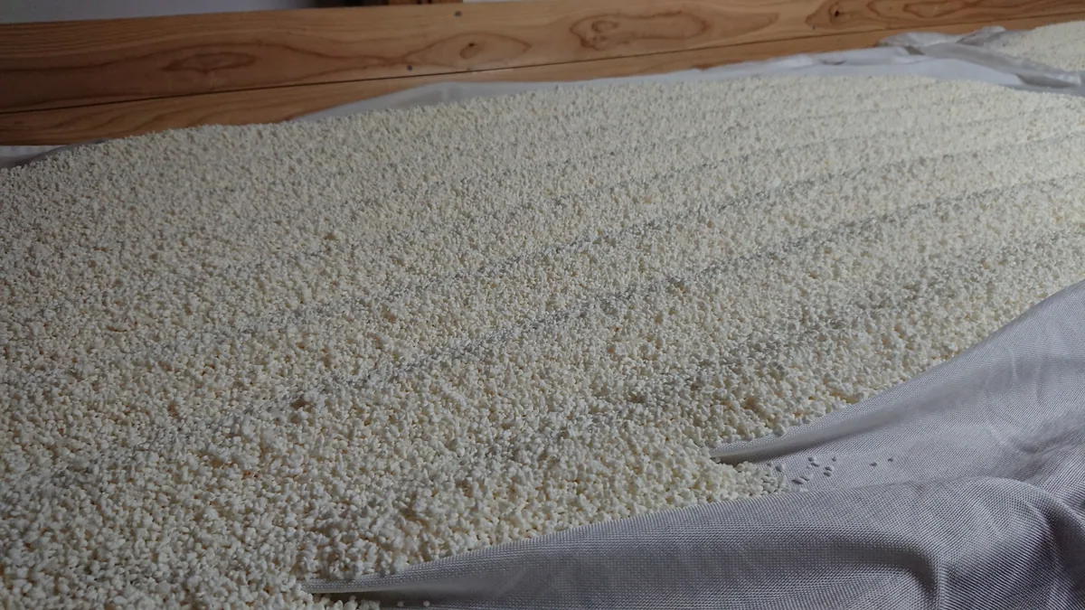 White rice grains spread across a cloth-lined wooden tray