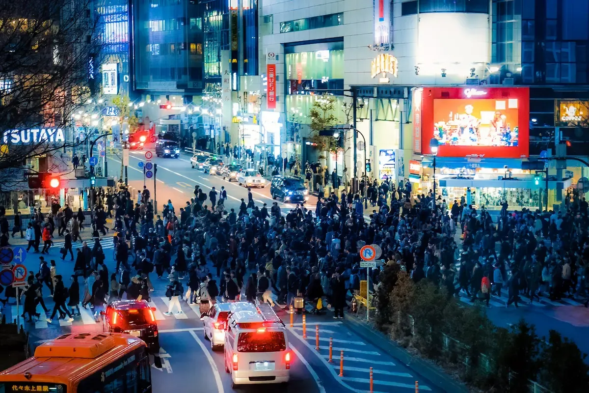 Crowds at Shibuya Crossing beneath illuminated signs