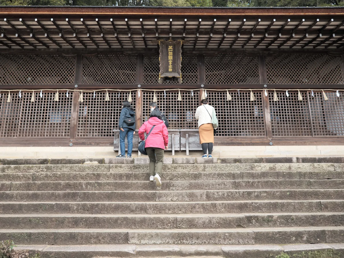 Visitors at the wooden main shrine building of Ujigami Shrine