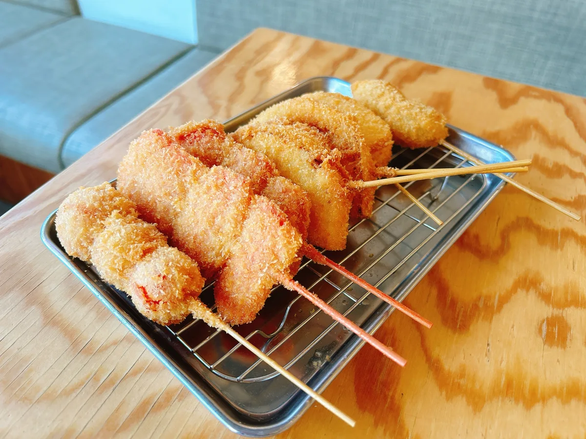 Breaded fried skewers arranged on a metal rack