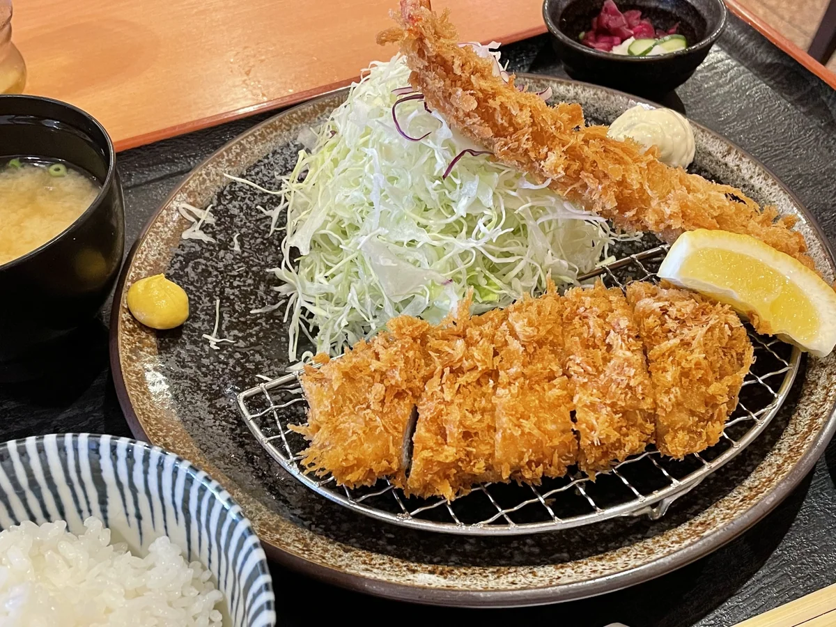 Sliced tonkatsu and a breaded shrimp with cabbage, rice, soup and pickles