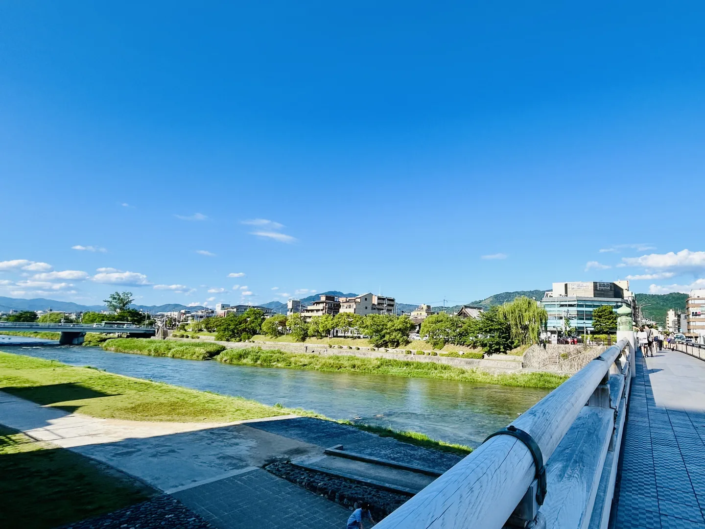 The Kamo River in central Kyoto, with riverside paths, willow branches and buildings along the bank