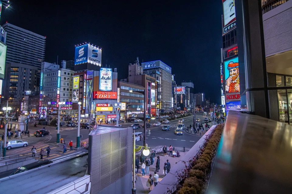 An elevated view of traffic and neon signs around central Susukino